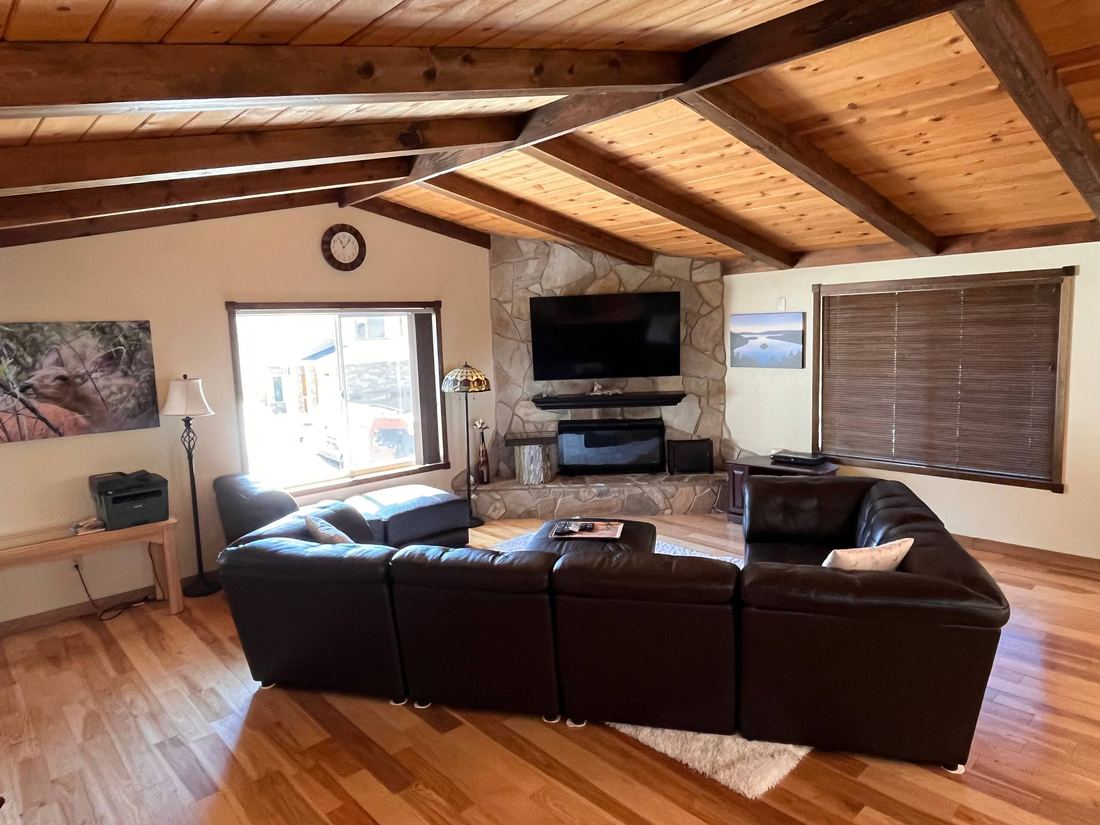 Living room with leather sectional and 65 inch TV